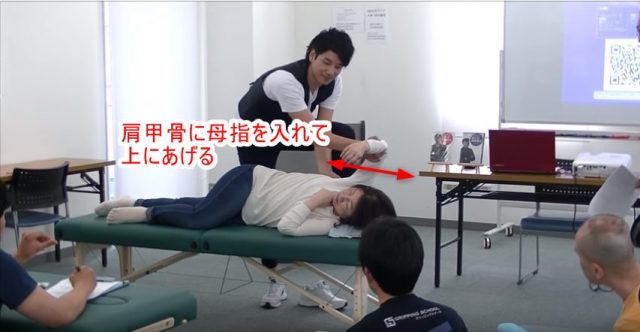 肩甲骨の内側に母指を入れて上にあげる