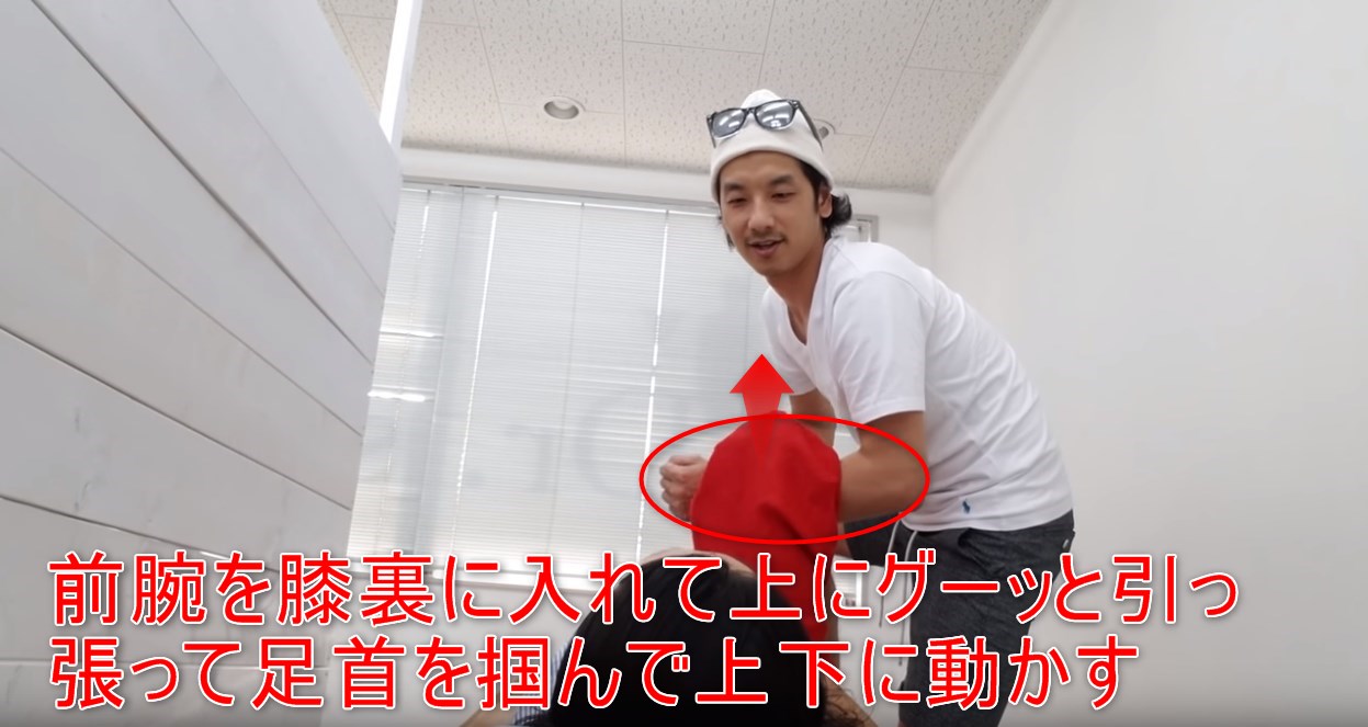 34-05_前腕を膝裏に入れて上にグーッと引っ張って足首を掴んで上下に動かす