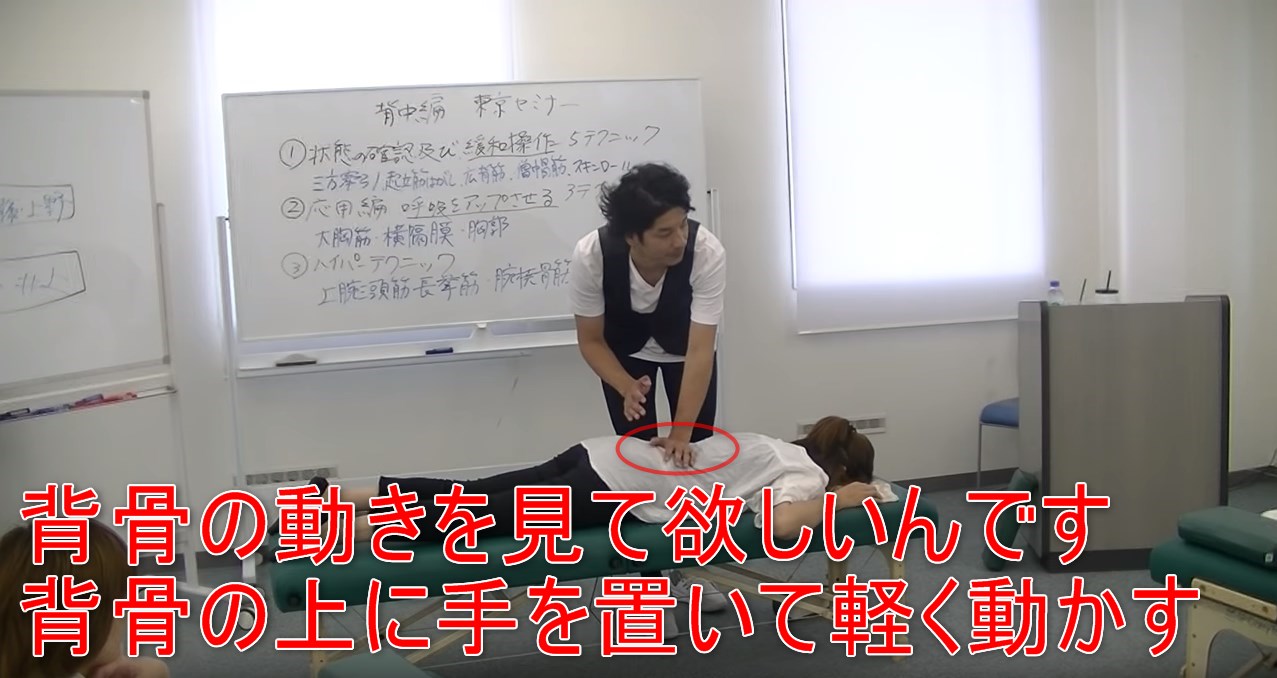 41-12_背骨の動きを見て欲しいんです背骨の上に手を置いて軽く動かす